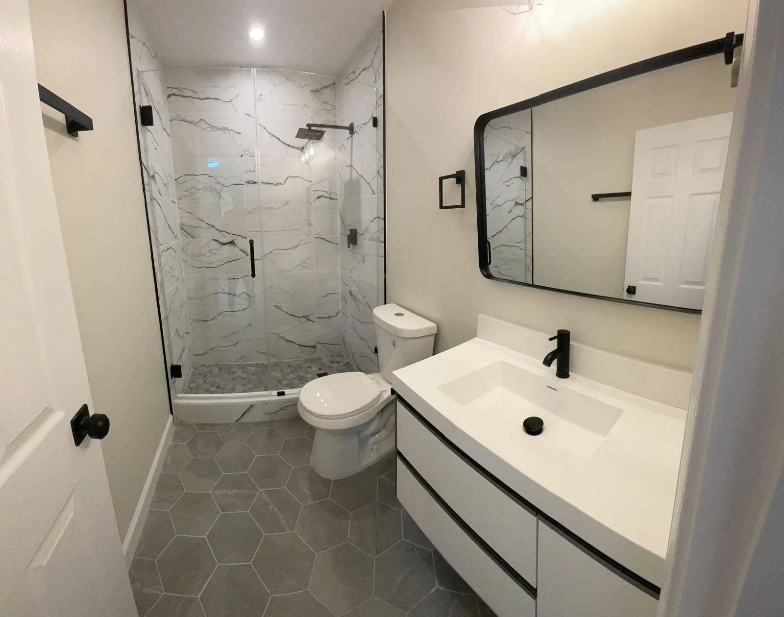 Marble shower, hex tile floor & black fixtures
