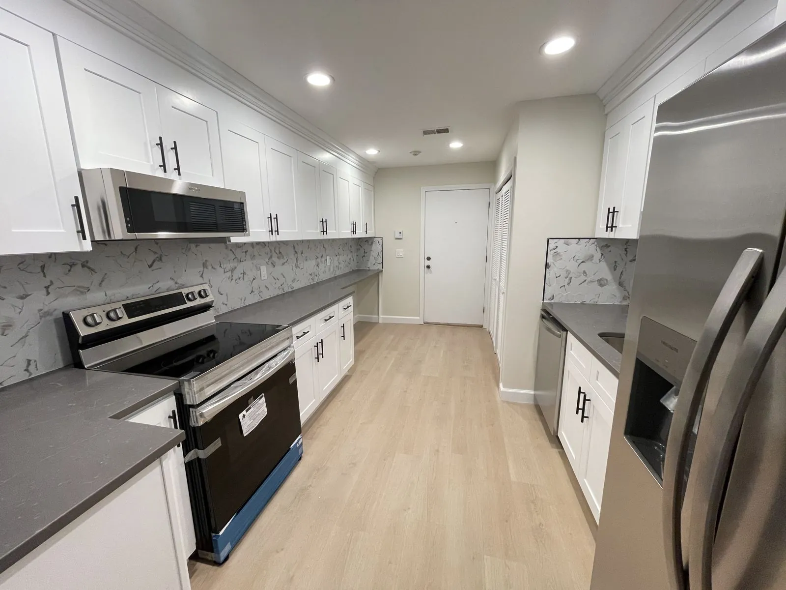White shaker galley with gray quartz counters